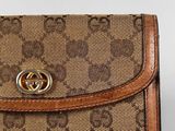a close up of a brown and tan guccissi wallet