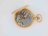 a close up of a pocket watch on a white surface