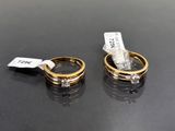 deux bagues en or serties de diamants, posées sur un fond noir, avec une étiquette de prix