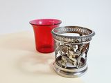 a red cup sitting next to a silver cup on a table
