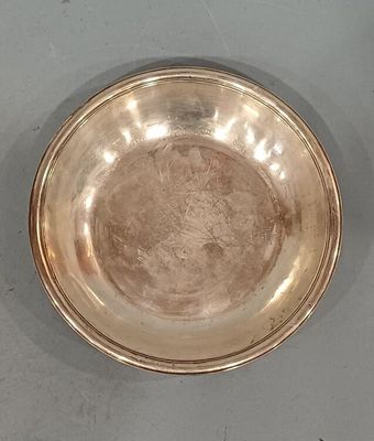 a silver plate on the table with a spoon in it