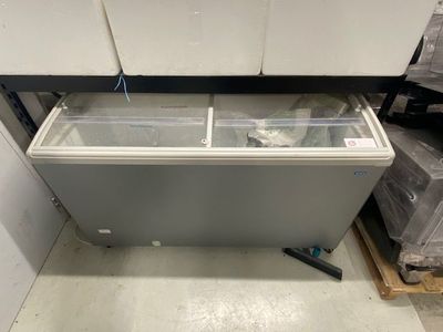 an open chest freezer sitting in a warehouse filled with boxes