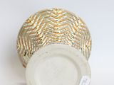a white vase with a gold and white design on it