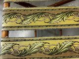 a close up of a wooden chair with a yellow and green striped seat