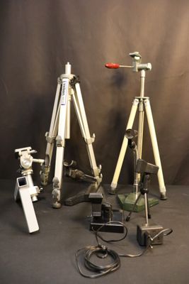 three tripods and a camera on a table
