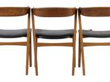 four wooden chairs with black leather seats on a white background