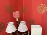 trois lampes posées sur une petite table dans un coin de la pièce