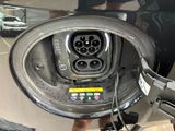 a close up of a car ' s charging station with a person standing next to it