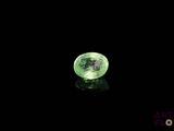 un gros plan d'un cristal vert sur une surface noire