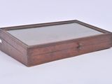 a small wooden box with a glass top on a white surface