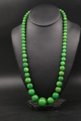 un collier de perles vertes sur un mannequin noir