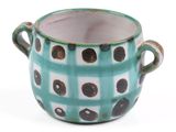 a green and white cup with black dots on it
