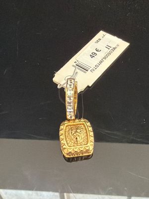 un petit pendentif en or auquel est attachée une étiquette