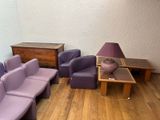 a room with purple couches, a table, and a lamp