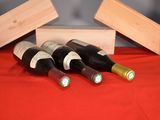 three bottles of wine in a wooden box on a red cloth