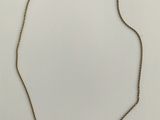 un collier en or orné d'une perle et de perles noires sur fond blanc
