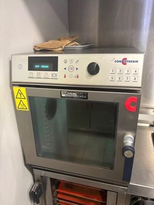 a silver oven with a glove on top of it