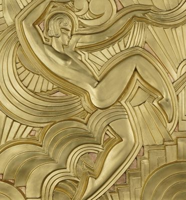 a gold sculpture on the wall of a building