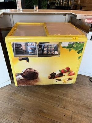 a yellow ice cream machine sitting in the middle of a kitchen