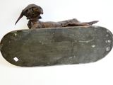 a statue of a dog sitting on top of a skateboard