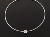 a silver necklace with a blue topaz stone on a black background