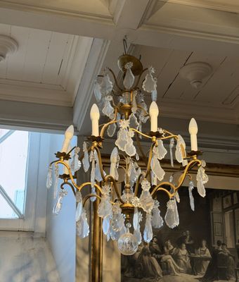 a chandelier in a room with a painting on the wall