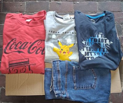 trois paires de jeans et un t-shirt posés sur un carton