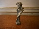 une petite statue représentant une femme assise sur une table