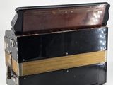 an old black and gold accordion sitting on top of a white table