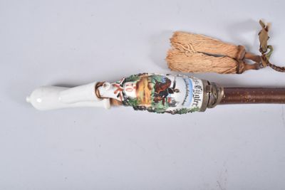 a white pipe with a brown handle and a brown handle