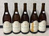 quatre bouteilles de vin sont alignées sur un comptoir