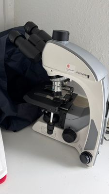 un microscope et un flacon de liquide posés sur une table