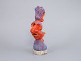 an orange and blue sculpture of a man with a mohawk on his head