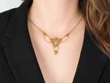 a woman wearing a black blazer and a gold necklace