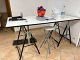 a white table with two stools and a bag on it