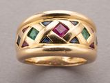a close up of a gold ring with multi colored stones