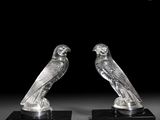 paire de figurines en cristal représentant deux oiseaux, posées sur des socles noirs