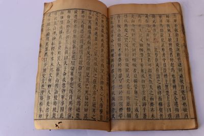 un vieux livre portant des caractères chinois, posé sur une table