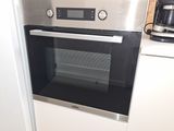 a stainless steel oven in a kitchen with a coffee maker