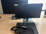 un ordinateur portable et un écran posés sur un bureau, avec une souris et un clavier