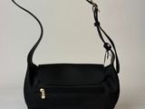 a black purse with a long strap on a white background