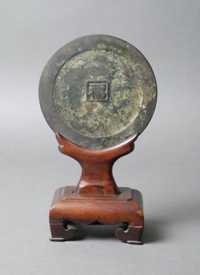 CHINE Miroir en bronze à décor d'un caractère central, sur u…