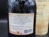 une vieille bouteille d'alcool posée à côté d'une bouteille de vin