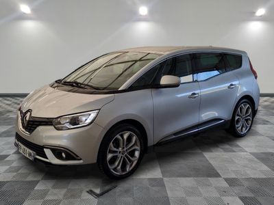 une voiture argentée est garée dans une pièce au sol en damier