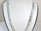 collier composé de perles de verre, muni d'un fermoir en argent, présenté sur un mannequin blanc