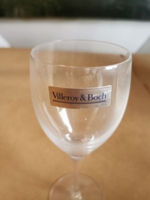 un verre à vin orné d'un autocollant, posé sur une table