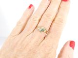 a woman ' s hand with a red manicure and a gold ring