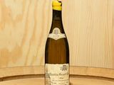une bouteille de vin posée sur un tonneau en bois