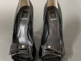 pair of black leather shoes with gold buckles on the toes