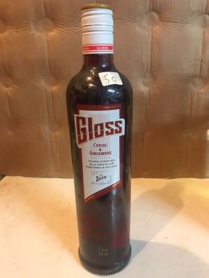 une bouteille de vin posée sur une table à côté d'un verre de vin